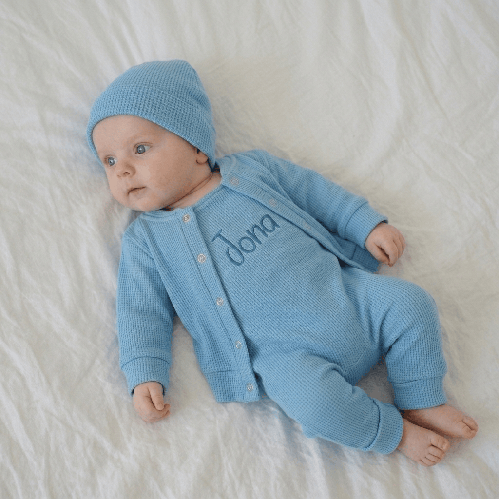 Dieses 3-teilige Baby Set aus Waffelstrick-Jersey in verschiedenen Blautönen, ist genau so ein Lieblingsstück: weich, liebevoll gefertigt und auf Wunsch ganz persönlich bestickt. Die Kombination aus Latzhose, passendem Baby Cardigan und einlagiger Mütze wirkt zeitlos, hochwertig und gleichzeitig wunderbar niedlich.