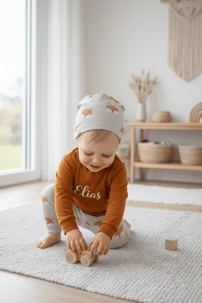 In Deutschland, handgemachtes Baby und Kinderset, bestehend aus einem Pullover mit Namen, einer dazu passenden Hose und Mütze.
