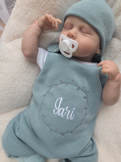 Baby Strampler gefüttert aus Sweat mit individueller Stickerei auf dem Vorderteil. Inklusive dazu passender Mütze aus Sweat.