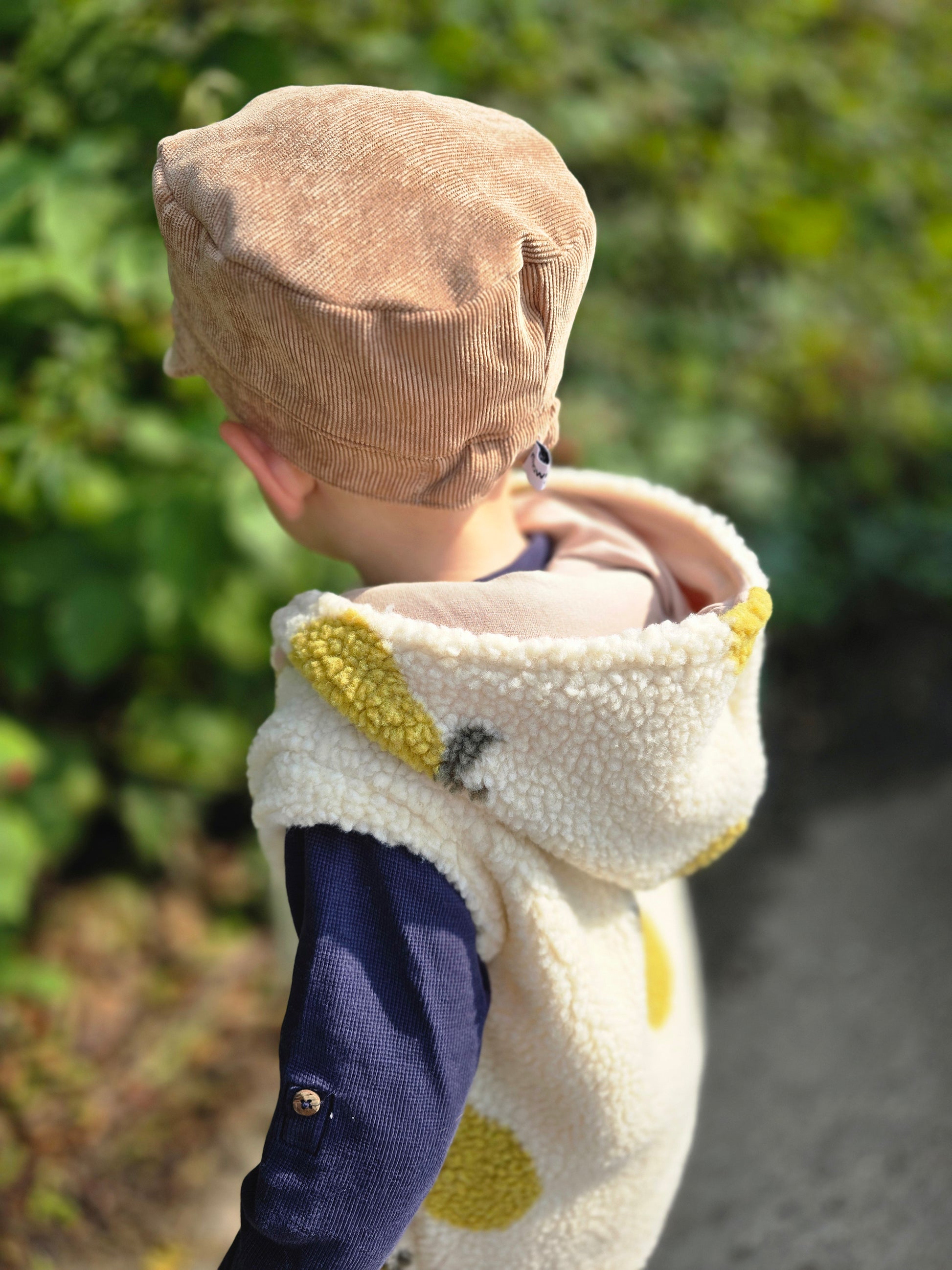 Weste aus einem flauschigem Teddystoff nach Wahl mit Kapuze und Reißverschluss. Gefüttert mit einem beigen Innenfutter.