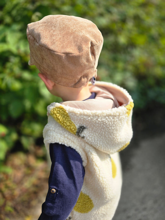 Weste aus einem flauschigem Teddystoff nach Wahl mit Kapuze und Reißverschluss. Gefüttert mit einem beigen Innenfutter.