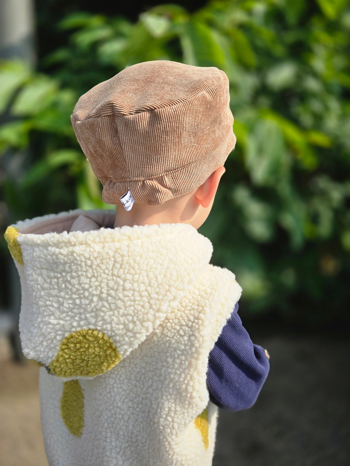 Weste aus einem flauschigem Teddystoff nach Wahl mit Kapuze und Reißverschluss. Gefüttert mit einem beigen Innenfutter.