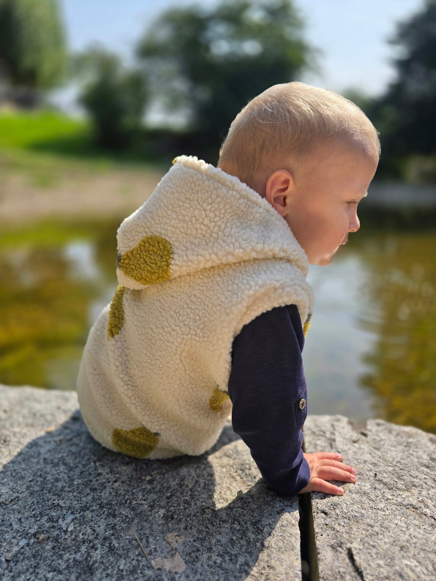 Weste aus einem flauschigem Teddystoff nach Wahl mit Kapuze und Reißverschluss. Gefüttert mit einem beigen Innenfutter.